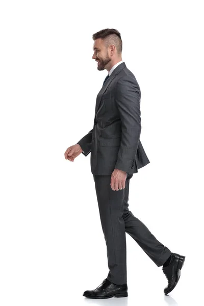 Vista lateral de um homem de negócios sorridente andando — Fotografia de Stock