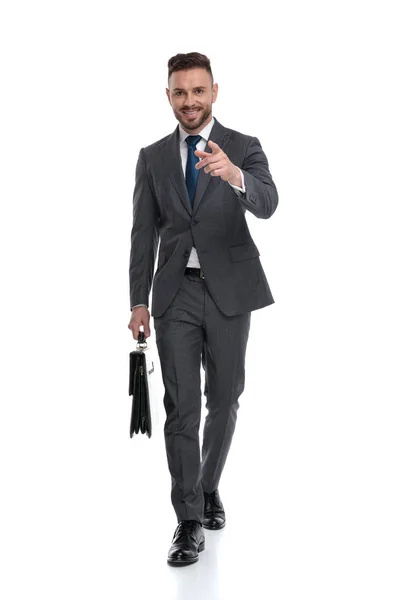 Caminhando jovem sorridente empresário está apontando o dedo para a frente — Fotografia de Stock