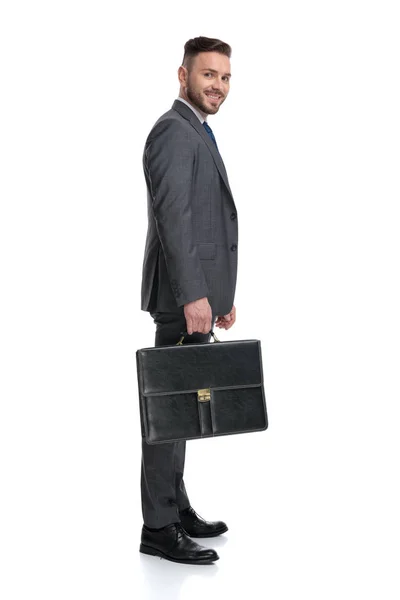 Sorridente giovane uomo d'affari in possesso di valigia è in attesa in linea — Foto Stock