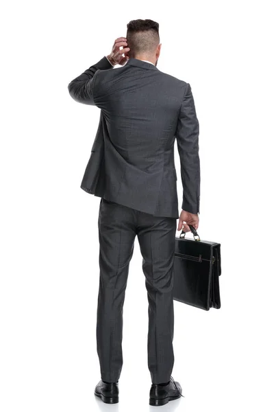 Vista posteriore di un uomo d'affari confuso che si gratta la testa — Foto Stock