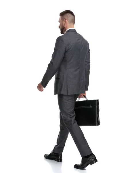 Πίσω πλευρική όψη ενός περπατήματος επιχειρηματία που κρατά ένα χαρτοφύλακα — Φωτογραφία Αρχείου