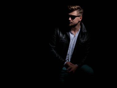 deri ceket ve güneş gözlüğü genç adam uzağa bakar