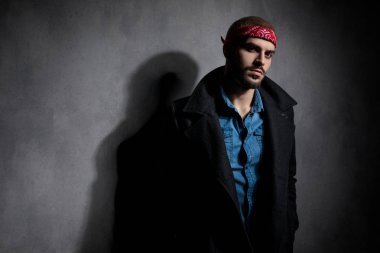 gri arka plan üzerinde ceplerinde el ele tutuşan çekici genç adam