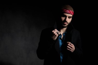 siyah arka plan üzerinde yaka tutan yakışıklı genç adam