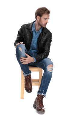 adam oturan ve bacağını tutarak