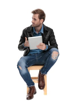 tablet ile oturmuş adam yanlara ukala görünümlü