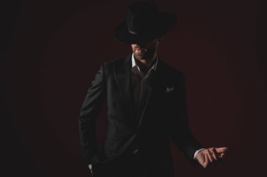 gizemli genç adam smokin giyen ve yan sunan