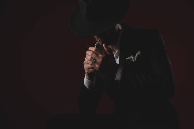 siyah arka plan üzerinde sigara aydınlatma gizemli genç adam