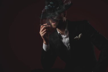 siyah arka plan üzerinde smokin sigara gizemli adam