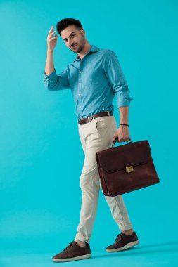 bir eliyle yürüyen evrak çantası ile adam