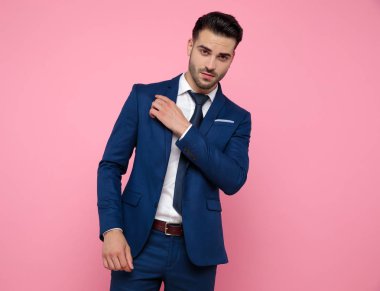 pembe arka plan üzerinde lacivert takım elbise giyen emin genç adam