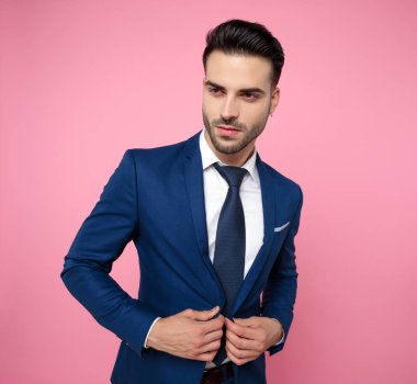 pembe arka plan üzerinde lacivert takım elbise giyen emin genç adam