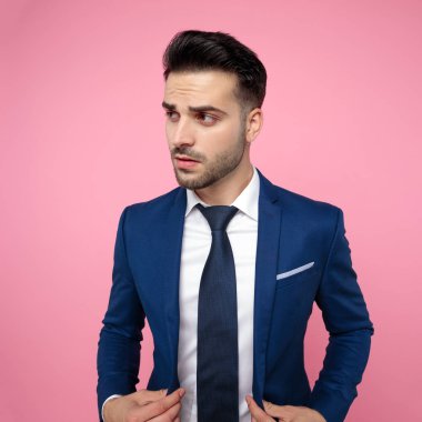 pembe arka plan lacivert takım elbise giyen yakışıklı genç adam