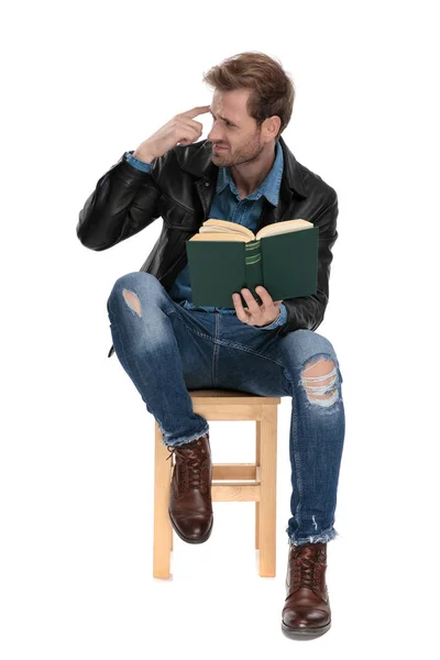 Sitzender Mann mit Buch imitiert verrückte Geste — Stockfoto