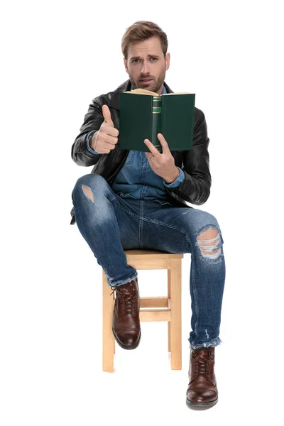 Mann sitzt mit Buch und Ok-Schild — Stockfoto