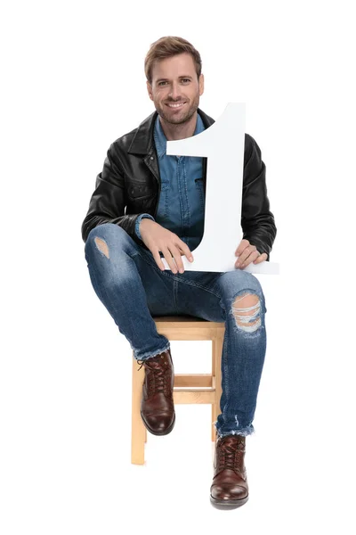 Muž sedící s číslem jedna v rukou šťastných — Stock fotografie