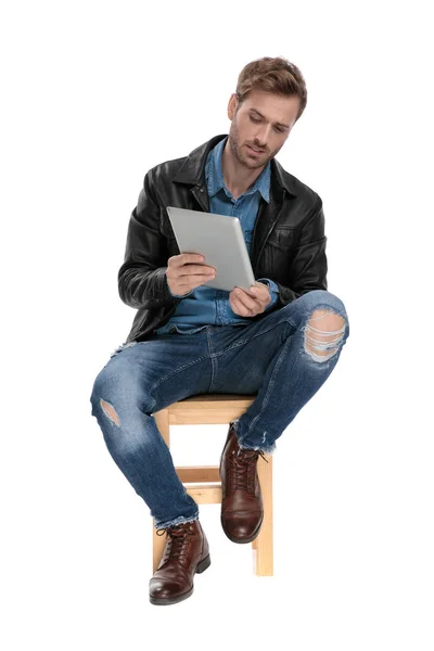 Seduto uomo mostrando qualcosa su tablet — Foto Stock