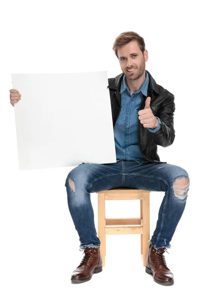 Сидящий человек, держащий бланк билборда с надписью "ОК" — стоковое фото