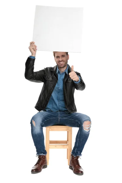 Sitzender Mann mit einer Werbetafel über dem Kopf mit Ok-Zeichen — Stockfoto