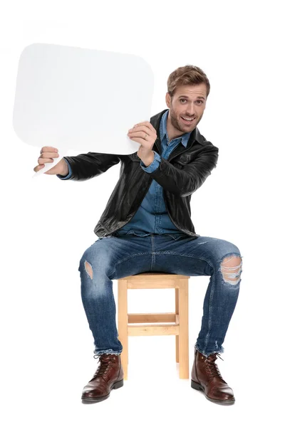 Καθήμενος άνθρωπος κρατώντας μια φούσκα ομιλίας σε μια πλευρά — Φωτογραφία Αρχείου