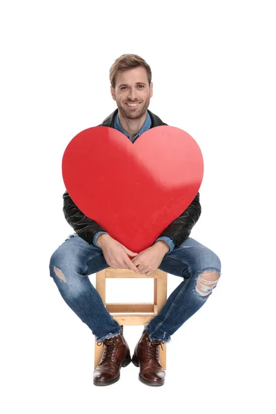 Sentado sosteniendo un gran corazón rojo —  Fotos de Stock