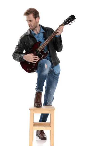 Άνθρωπος παίζοντας την κιθάρα παθιασμένο και κοιτάζοντας πλάγια — Φωτογραφία Αρχείου