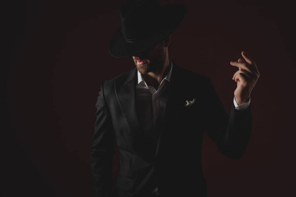 mysterious man wearing tuxedo and black hat 