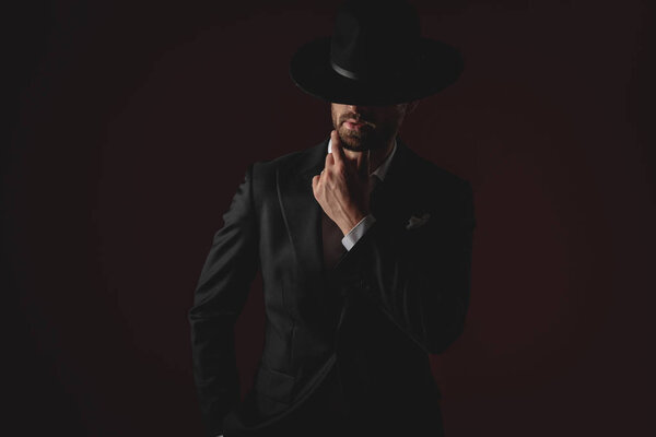 mysterious young man wearing tuxedo and black hat