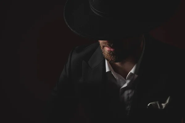 Close up of mysterious young man in tuxedo on black background — Stock Photo, Image