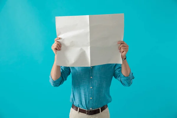 Człowiek stojący z twarzą objętą gazetą — Zdjęcie stockowe