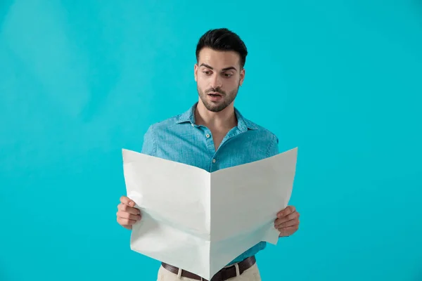 Man reading the newspaper shocked — Stock Photo, Image