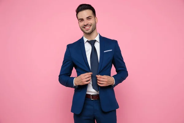 Attraente giovane uomo che indossa blu navy vestito su sfondo rosa — Foto Stock