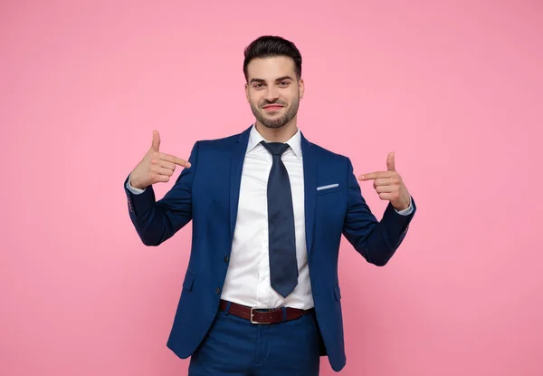 Attraktiv ung man pekar fingrar till sig själv på rosa backgro — Stockfoto