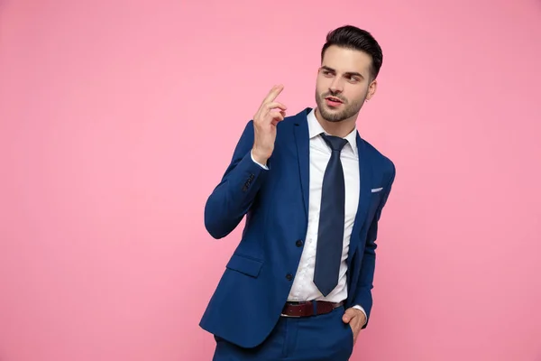 Aantrekkelijke jonge man op zoek naar kant op roze achtergrond — Stockfoto