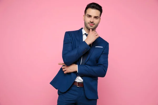 Attraktiver junger Mann zeigt mit dem Finger zur Seite auf rosa Hintergrund — Stockfoto
