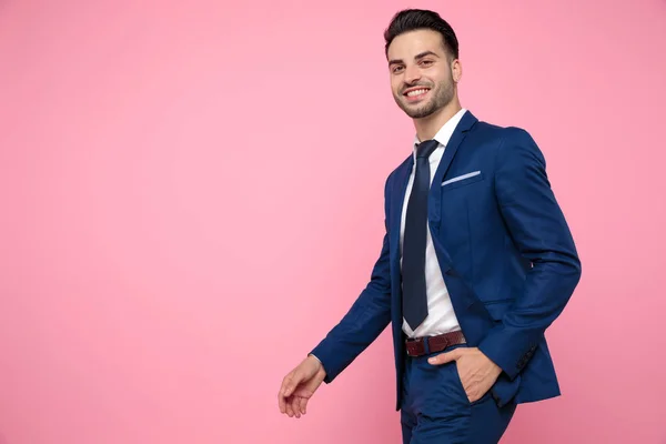 Homem casual inteligente andando sobre fundo rosa no estúdio — Fotografia de Stock