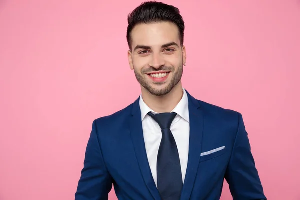 Close-up van aantrekkelijke jonge man glimlachend op roze achtergrond — Stockfoto