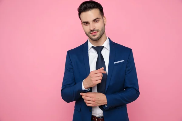 Attraktiver junger Mann im marineblauen Anzug auf rosa Hintergrund — Stockfoto