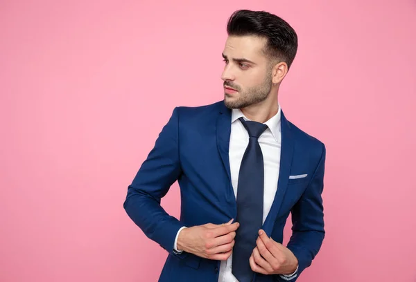 Csinos fiatalember megszervezése kabát rózsaszín háttér — Stock Fotó