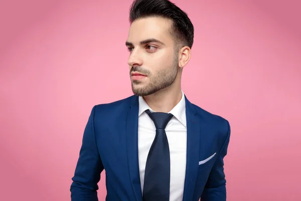 Attractive young man looking to side on pink background — Stock Photo, Image