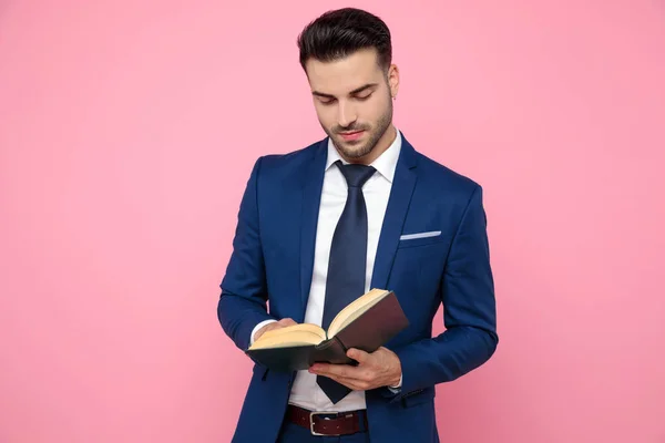 Hombre casual inteligente leyendo sobre fondo rosa en el estudio —  Fotos de Stock