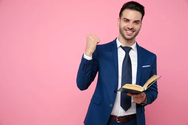 Joven atractivo leyendo un libro sobre fondo rosa —  Fotos de Stock