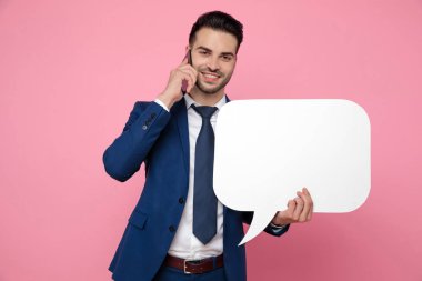 handsome man holding speech bubble and talking on the phone clipart