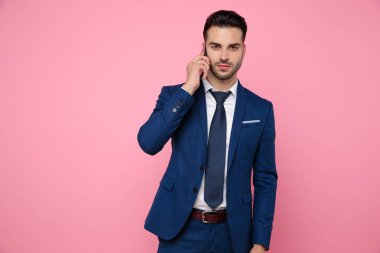 pembe arka plan üzerinde telefonda konuşurken çekici genç adam