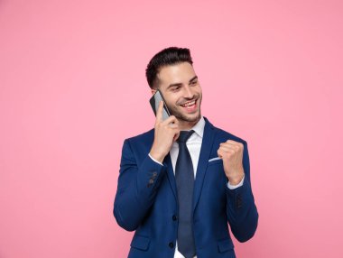 yakışıklı genç adam pembe arka plan üzerinde telefonda konuşurken 