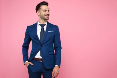 pembe arka plan üzerinde cebinde el tutan akıllı rahat adam