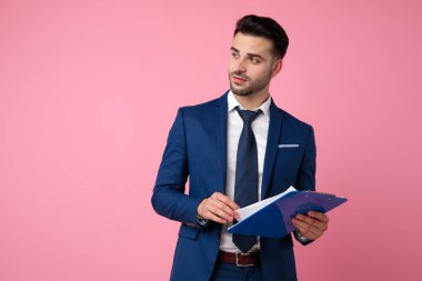 pembe arka plan üzerinde sayfaları çeviren çekici genç adam