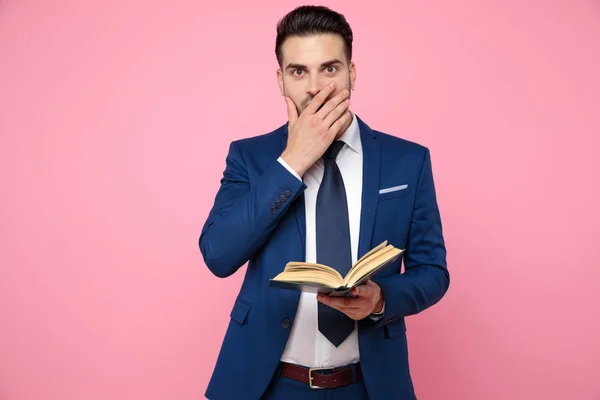 Smart Casual man håller en bok om rosa bakgrund — Stockfoto