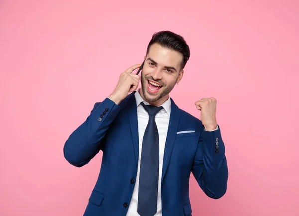 Attractive young man talking on the phone on pink background — Stock Photo, Image
