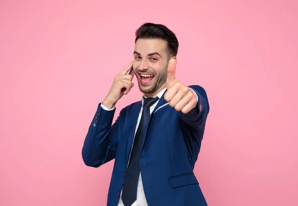 Hombre guapo hablando por teléfono y haciendo pulgares hacia arriba signo — Foto de Stock